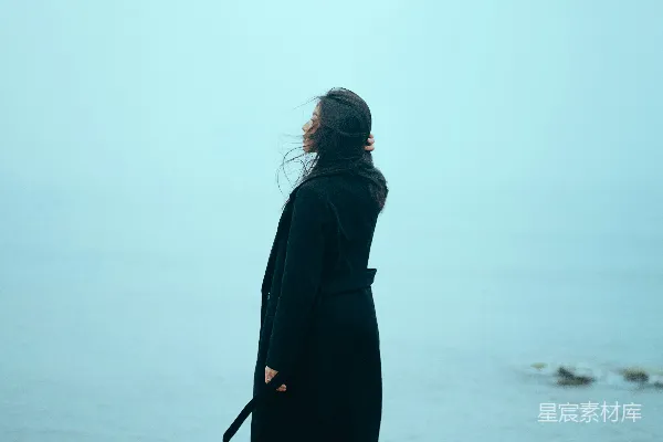 高清摄影 一个女人站在岩石上，望着大海。