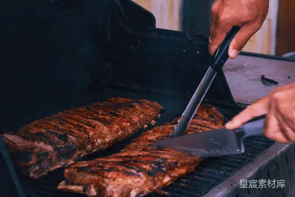 高清摄影 一个男人正在用 grill 烤一些肉。