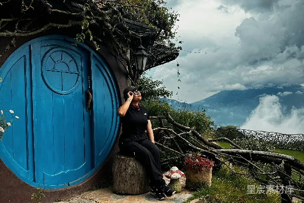 高清摄影 一位妇女正在拍摄一只霍比特屋的照片。