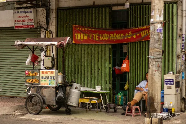 高清摄影 一个男人坐在一辆食品车前面。