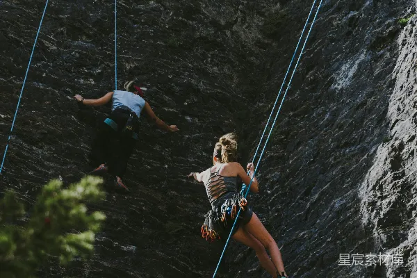 高清摄影 橙色上衣的男人正在攀绳。