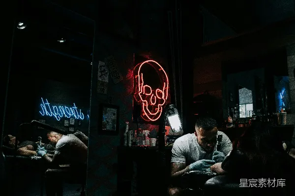高清摄影 一个男人坐在一间黑暗房间里的桌子旁。