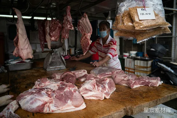 高清摄影 市场里戴着口罩的屠夫正在切割生猪肉