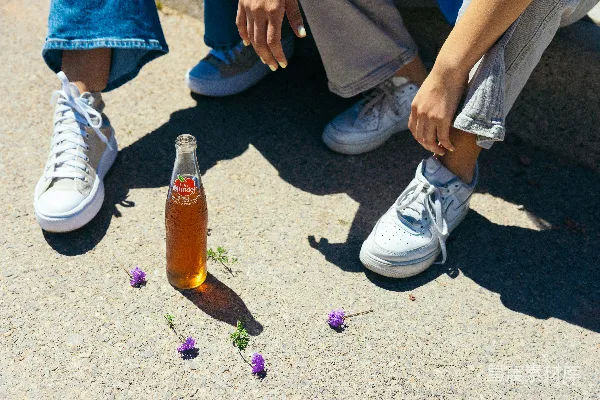 高清摄影 地上摆放着一瓶啤酒，旁边是一双鞋子。