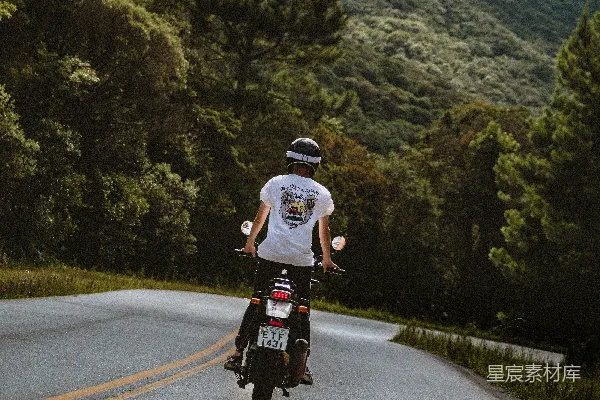 高清摄影 白T恤的男人在白天骑自行车在路上骑行。