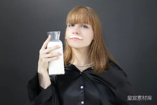 高清摄影 一个女人拿着一个玻璃杯和一瓶牛奶