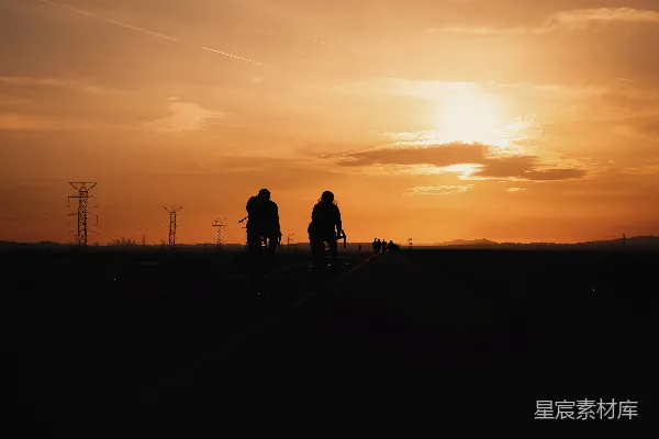 高清摄影 夕阳下两个人在场地上行走的剪影