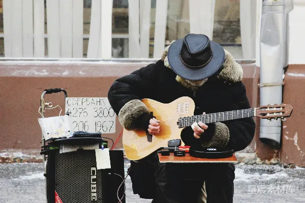 高清摄影 男人在建筑物附近弹吉他