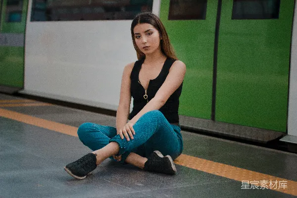高清摄影 黑色袖克except上衣和蓝色牛仔裤的女人坐在火车隧道小径上