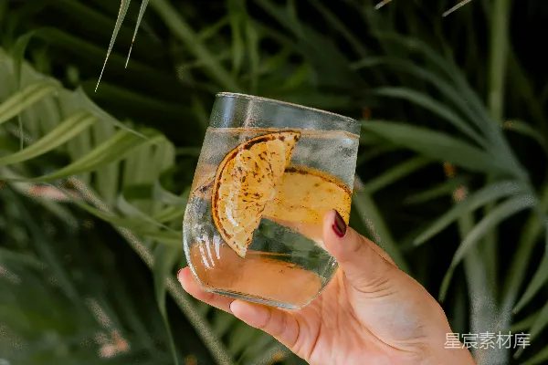 高清摄影 手持透明玻璃杯的人拿着一杯棕色液体。