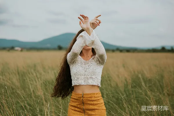 高清摄影 身穿灰色 cropped 薄呢上衣的女子在草地上。
