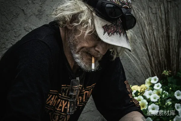 高清摄影 黑色T恤上衣的男人戴着黑色墨镜和白色帽子，手持智能手机。