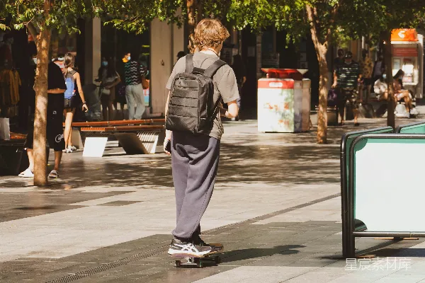 高清摄影 一个少年在人行道上骑着滑板车滑行