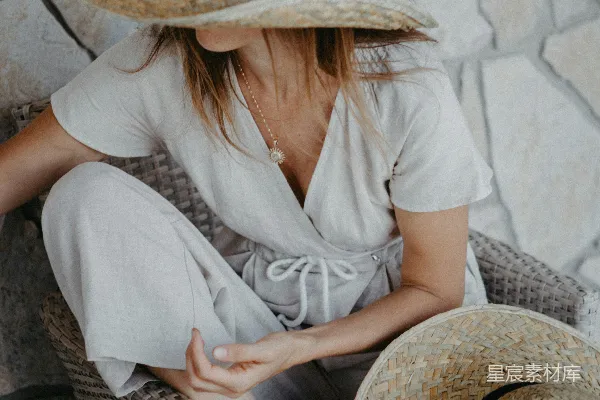 高清摄影 一个女人坐在椅子上，戴着一顶帽子。
