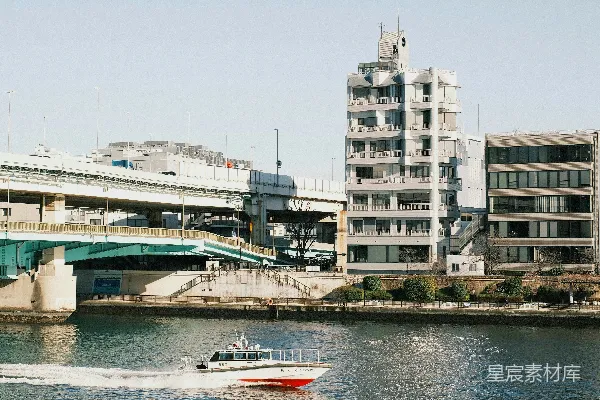 高清摄影 一艘船沿着河边驶向一座桥