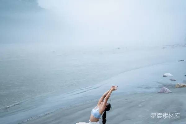 高清摄影 一位女性正在海滩上做瑜伽姿势。