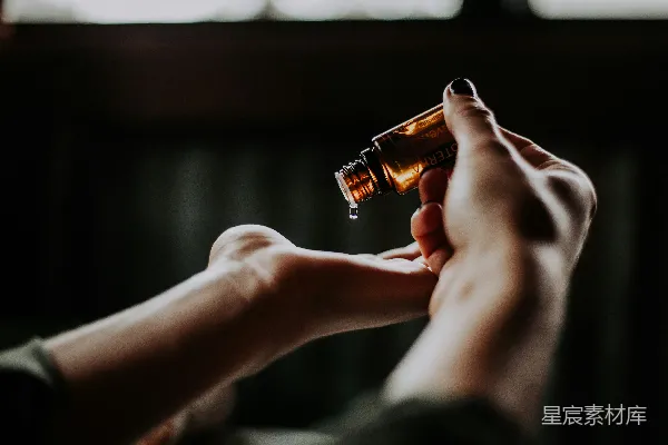 高清摄影 手持琥珀色玻璃瓶的人