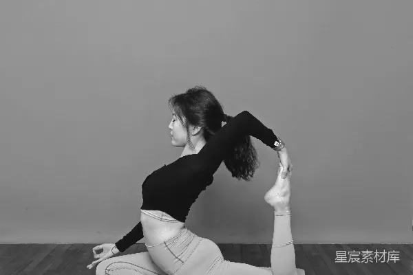 高清摄影 黑色上衣穿著的女子坐在地板上，穿着白色长裤。