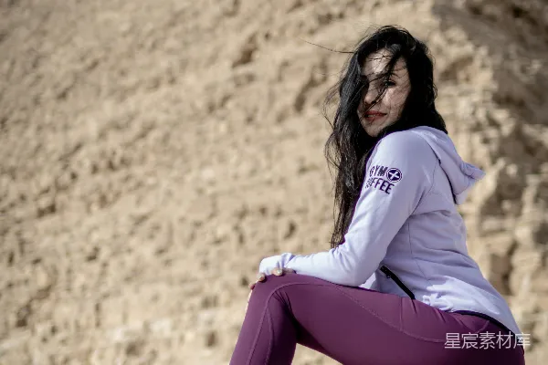 高清摄影 地上坐着一位妇女，她面前是一座金字塔。