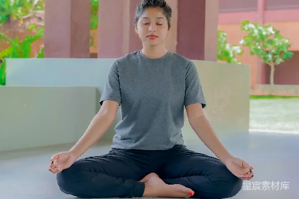 高清摄影 一个男人坐在莲花坐姿前的一栋建筑前