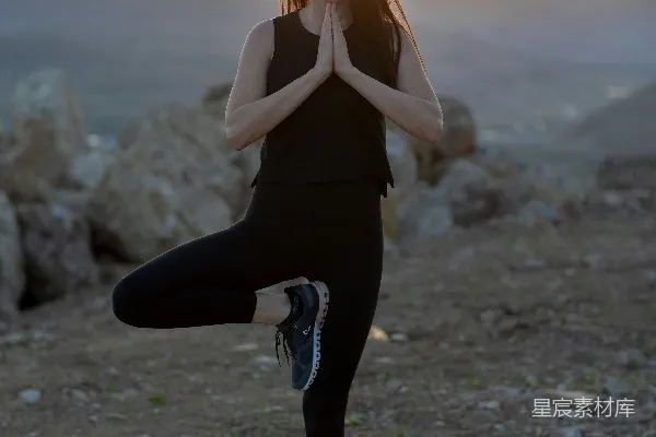 高清摄影 黑色连衣裙上衣和黑色裤子的女人站在岩石海岸的黄昏时刻