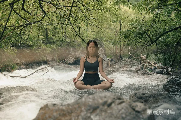 高清摄影 一位妇女坐在河边冥想。