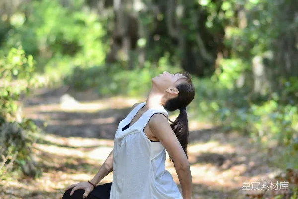 高清摄影 一个女人正在森林里做瑜伽。