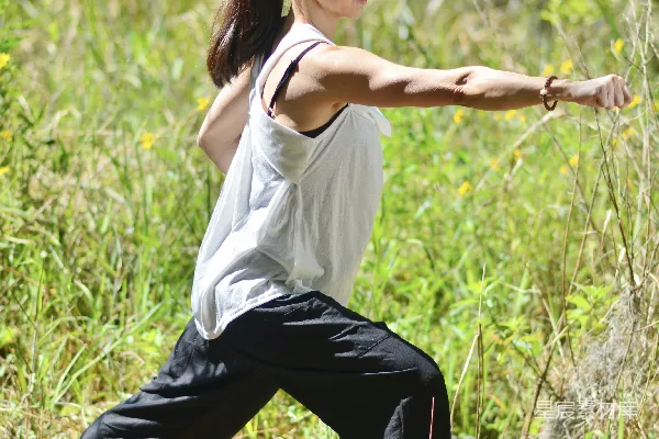 高清摄影 一个穿白衬衫和黑裤子的女人正在做瑜伽姿势