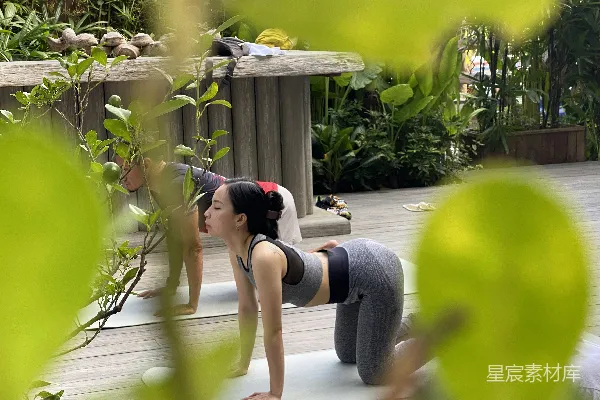 高清摄影 一位女性正站在瑜伽垫上做着一个瑜伽姿势。