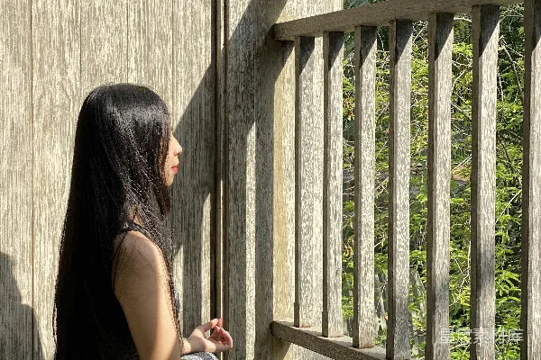 高清摄影 一个女人坐在门廊上，双腿交叉。