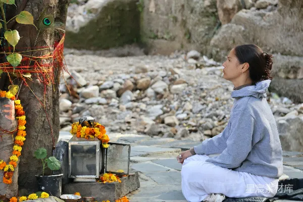 高清摄影 女性在神社附近打坐，周围有鲜花。