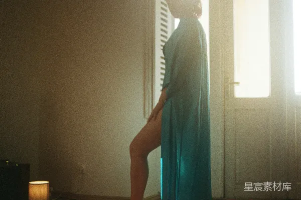 高清摄影 一个穿着蓝色连衣裙的女人站在窗户前