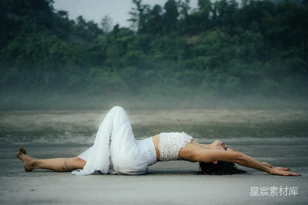 高清摄影 一个女人躺在沙滩上仰面朝天。