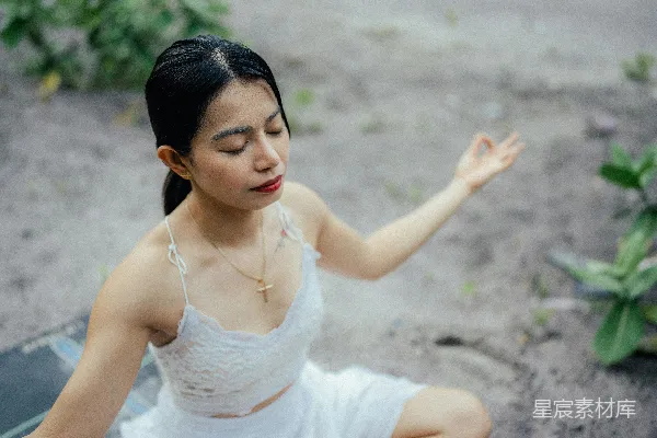 高清摄影 一个穿白色连衣裙的女人坐在地上。