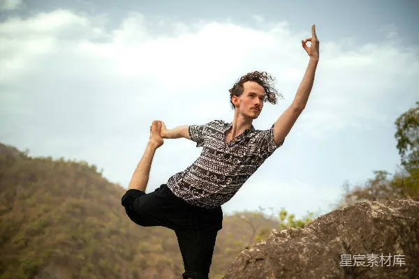 高清摄影 一个男人在岩石上做瑜伽姿势。