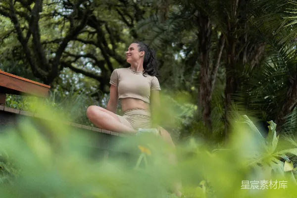 高清摄影 一位妇女在绿树成荫的户外进行冥想。