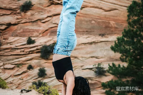 高清摄影 一个女人站在岩石上做倒立