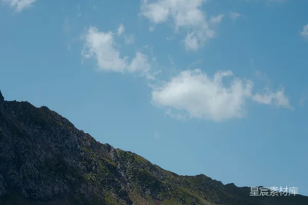 高清摄影 蓝天白云间绿山与褐山的白天景象