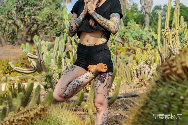 高清摄影 黑裙女子站在绿色植物旁，白天。