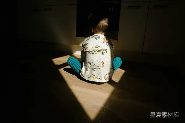 高清摄影 一个幼童坐在厨房的地板上。