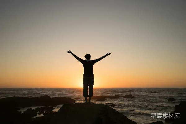 高清摄影 夕阳下一个人举起双臂的轮廓。