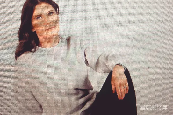 高清摄影 灰衬衣女子坐在那里，穿着黑色长裤。