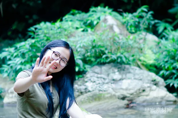高清摄影 一个女人坐在水边的岩石上