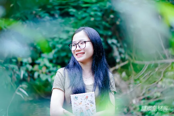 高清摄影 一个蓝发戴着眼镜的女人手持一本书