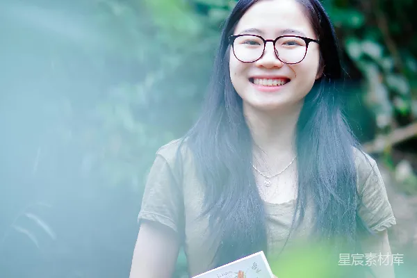 高清摄影 戴着眼镜的女人手里拿着一本书