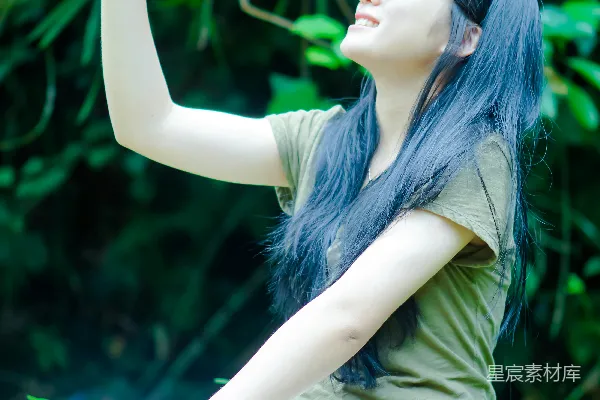 高清摄影 一个女人坐在岩石上，手里拿着植物。