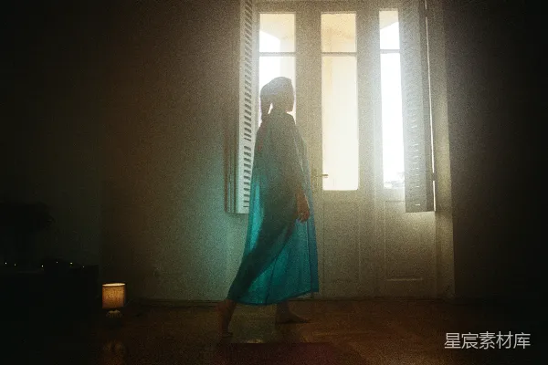 高清摄影 一个女人站在一间黑暗房间的门口。