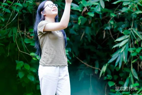 高清摄影 一个女人站在一片浓绿的森林前