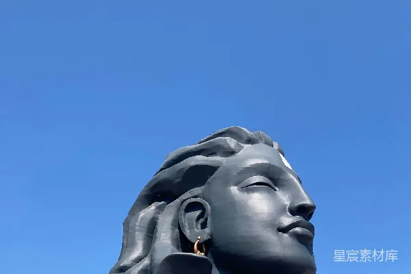 高清摄影 一位男子站在蓝天背景下巨大的雕像