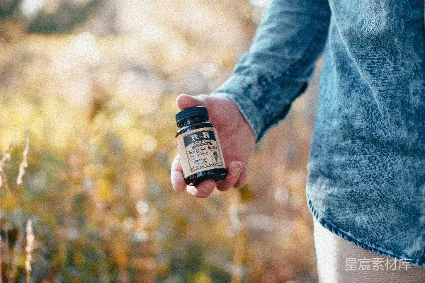 高清摄影 手持 beige 和 black 玻璃瓶的人